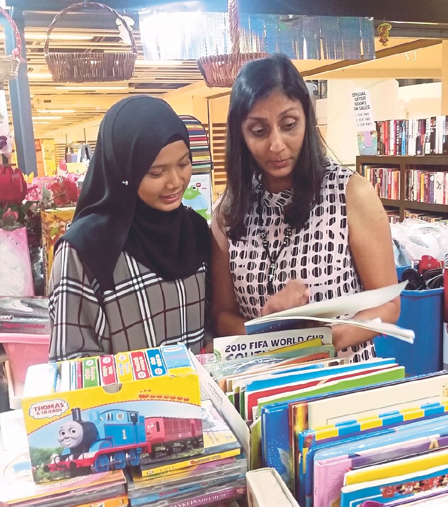 FARAH NISHA (kiri) bersama Jaya B melihat buku dan majalah yang dijual di kedai Jumble Station, Jaya One.