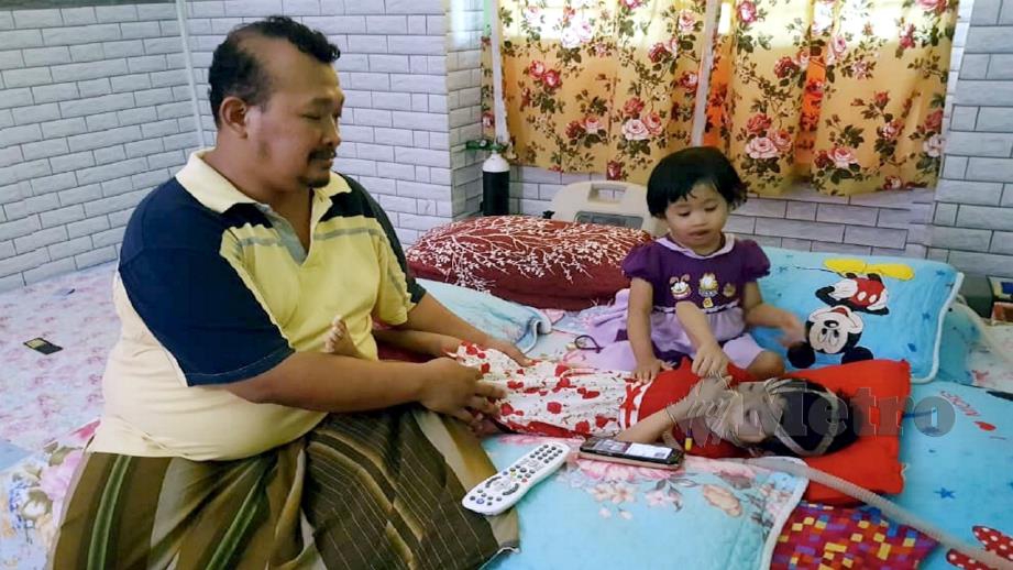 Mohd Najib bersama anaknya Nur Qaseh yang terlantar menderita masalah paru-paru akibat jangkitan adenovirus di rumahnya Taman Seri Duyong 3, Melaka. Foto Mohd Hilmie Hussin