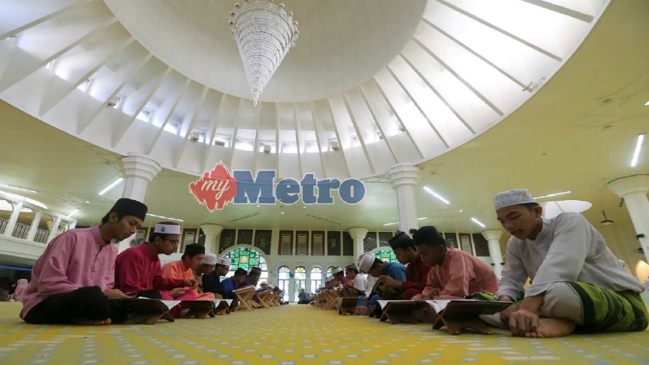 PELAJAR membaca al-Quran pada majlis Khatam al-Quran dan Iftar Perdana di Masjid Al Muktafi Billah Shah, Kuala Terengganu. FOTO ARKIB Ghazali Kori