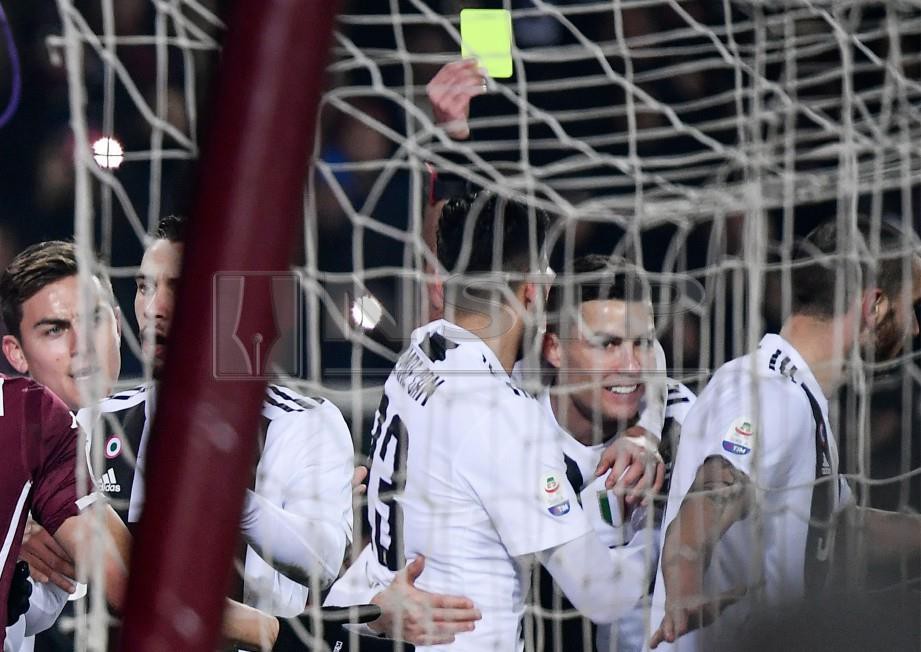 RONALDO (dua dari kanan) menerima kad kuning selepas melakukan provokasi ke atas penjaga gol Torino. -Foto AFP