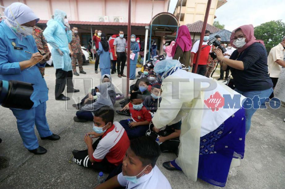 Pasukan perubatan memberi bantuan kepada murid-murid yang terhidu bahan kimia di Sekolah Kebangsaan Taman Pasir Putih, Pasir Gudang. FOTO Hairul Anuar Rahim.