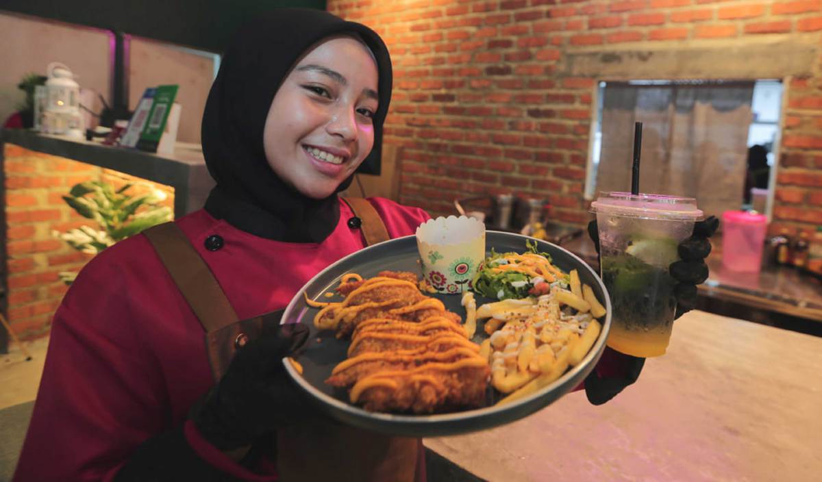 PEKERJA restoran, Nor Ellya Zulaikha Zuhaidi, 20, menunjukkan Menu Rahmah berharga RM5 dengan air yang dijual di Samballana Bistro, Bandar Dato' Onn, Johor. FOTO Nur Aisyah Mazalan