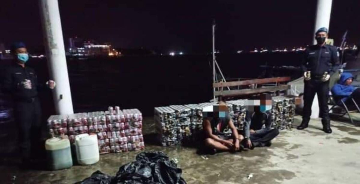 Dua suspek bersama minuman keras yang ditahan anggota PPM Labuan dalam operasi di periaran Tanjung Aru, Labuan. FOTO IHSAN PPM