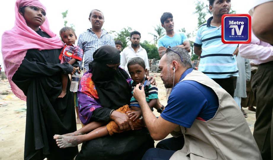 DR Ferwahn (kanan) merawat seorang kanak-kanak ketika misi bantuan kemanusiaan Rohingya Muslim Care Malaysia. FOTO Mohamad Shahril Badri Saali