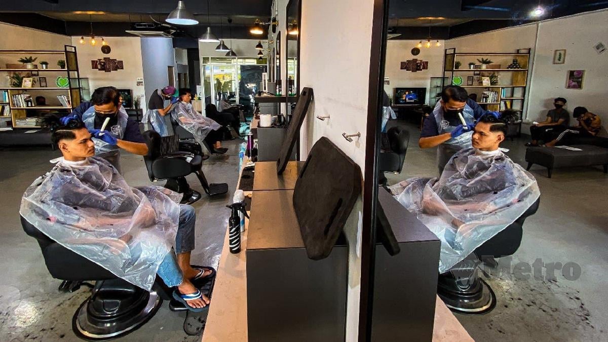 Pelanggan menggunting rambut di salah sebuah kedai gunting di Arau yang dibenarkan beroperasi selepas Perlis beralih ke Fasa Kedua PPN. FOTO LUQMAN HAKIM ZUBIR
