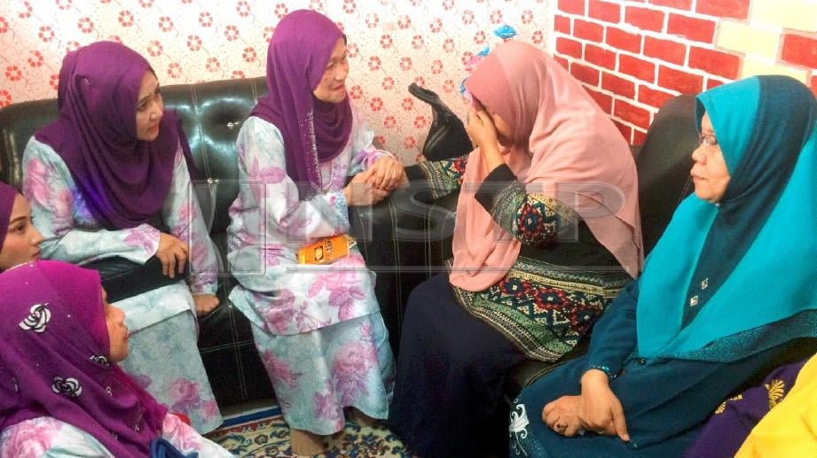 Ramlah (dua dari kanan) tidak dapat menahan sebak ketika dikunjungi Pengerusi JASMINE, Nora  (tengah) bersama ahli  JASMINE di rumahnya. FOTO Nurul Amanina Suhaini