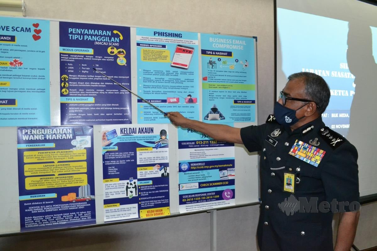 Ramli Mohamed menunjukkan poster berkaitan kes komersil di Ibu Pejabat Polis Kontinjen Pahang, Kuantan. FOTO ASROL AWANG