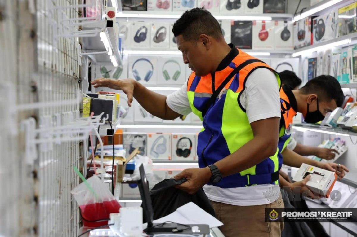PENGUAT KUASA DBKL menjalankan sita terhadap barangan jualan penjaja warga asing di sekitar Jalan Petaling dan Jalan Hang Lekir, Sabtu lalu. FOTO ihsan DBKL