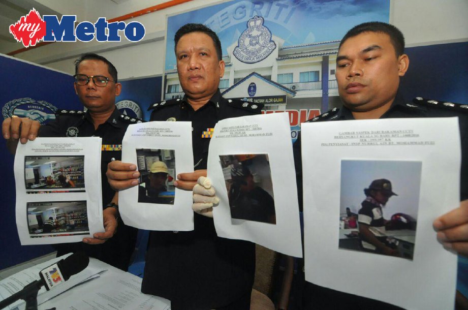 A Asmadi (tengah) bersama anggotanya menunjukkan gambar tiga suspek yang merompak premis menjual telefon bimbit dan aksesori ketika sidang media di Ibu Pejabat Daerah (IPD) Alor Gajah, Melaka.  FOTO Muhammad Hatim Ab Manan 