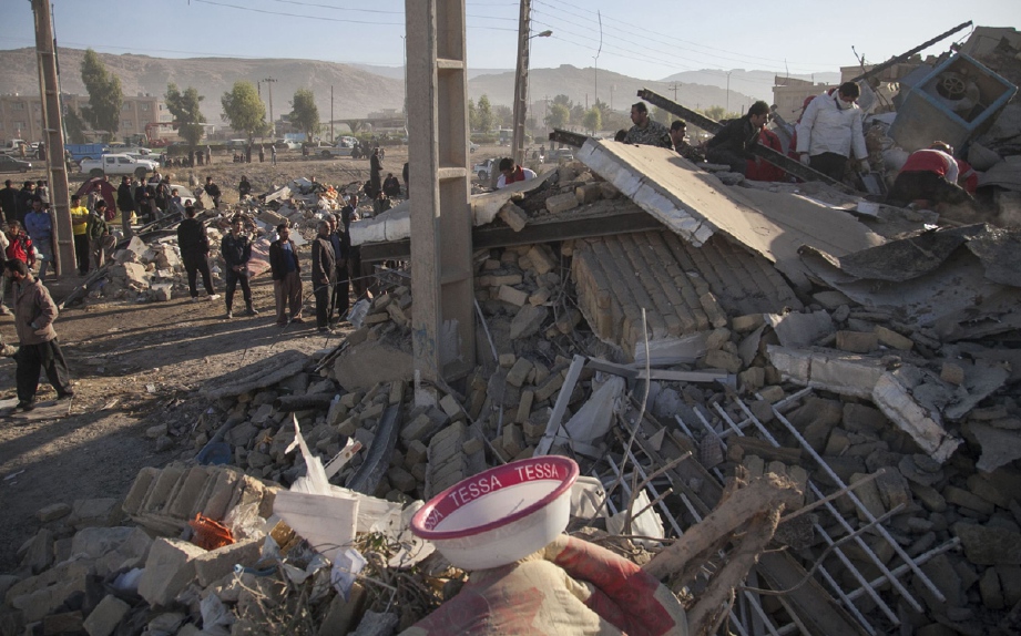 Pasukan penyelamat Iran menggeledah runtuhan di  di Pole-Zahab, wilayah Kermanshah, bagi mencari mangsa yang terperangkap. - Foto AFP