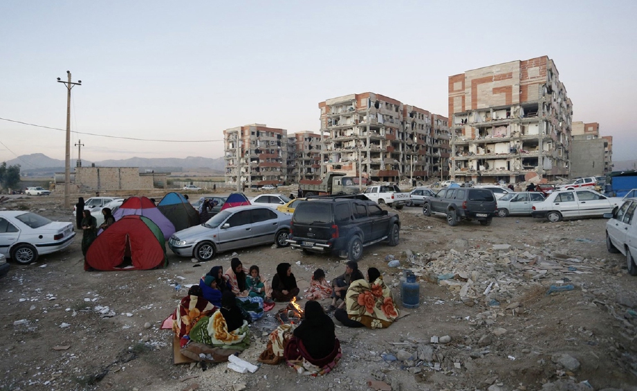 Mangsa gempa bumi di Pole-Zahab, wilayah Kermanshah, Iran, berkumpul di kawasan lapang berhampiran bangunan yang rosak teruk. - Foto EPA