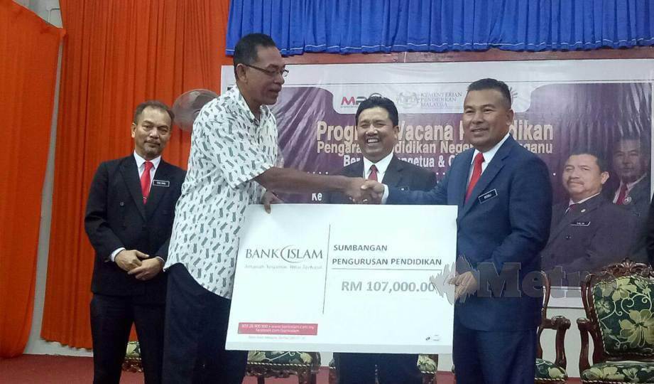 ROSOL (dua kiri) menyampaikan replika cek bernilai RM107,000 kepada Pegawai Pendidikan Daerah Hulu Terengganu, Rosli Chik (dua kanan) pada majlis wacana pendidikan dan sumbangan bantuan kewangan pengurusan PIBG daerah Hulu Terengganu.FOTO Baharom Bakar