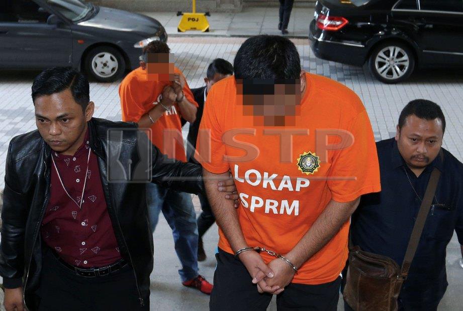PENGAWAI SPRM membawa seorang timbalan pengarah sebuah agensi kerajaan antara dua individu ditahan reman berhubung kelulusan projek Pemberian Perkhidmatan Sejagat (USP) di Mahkamah Majistret Putrajaya. FOTO Ahmad Irham Mohd Noor.