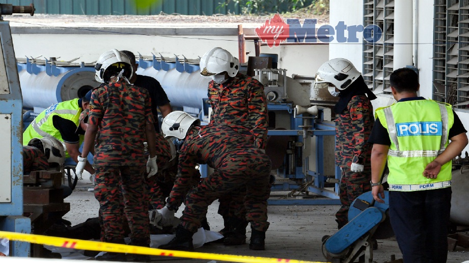 ANGGOTA bomba mengangkat mayat mangsa dalam kejadian letupan di sebuah kilang kejuruteraan elektrik di Kawasan Perindustrian Kundang, hari ini. FOTO Bernama