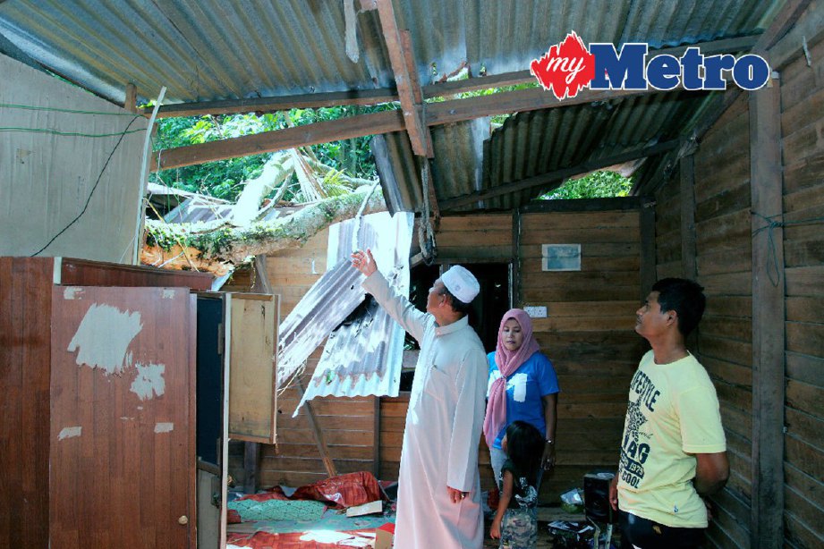 Mat Razi (kiri) melawat rumah mangsa ribut di Pengkalan Kubor. FOTO Nik Abdullah Nik Omar