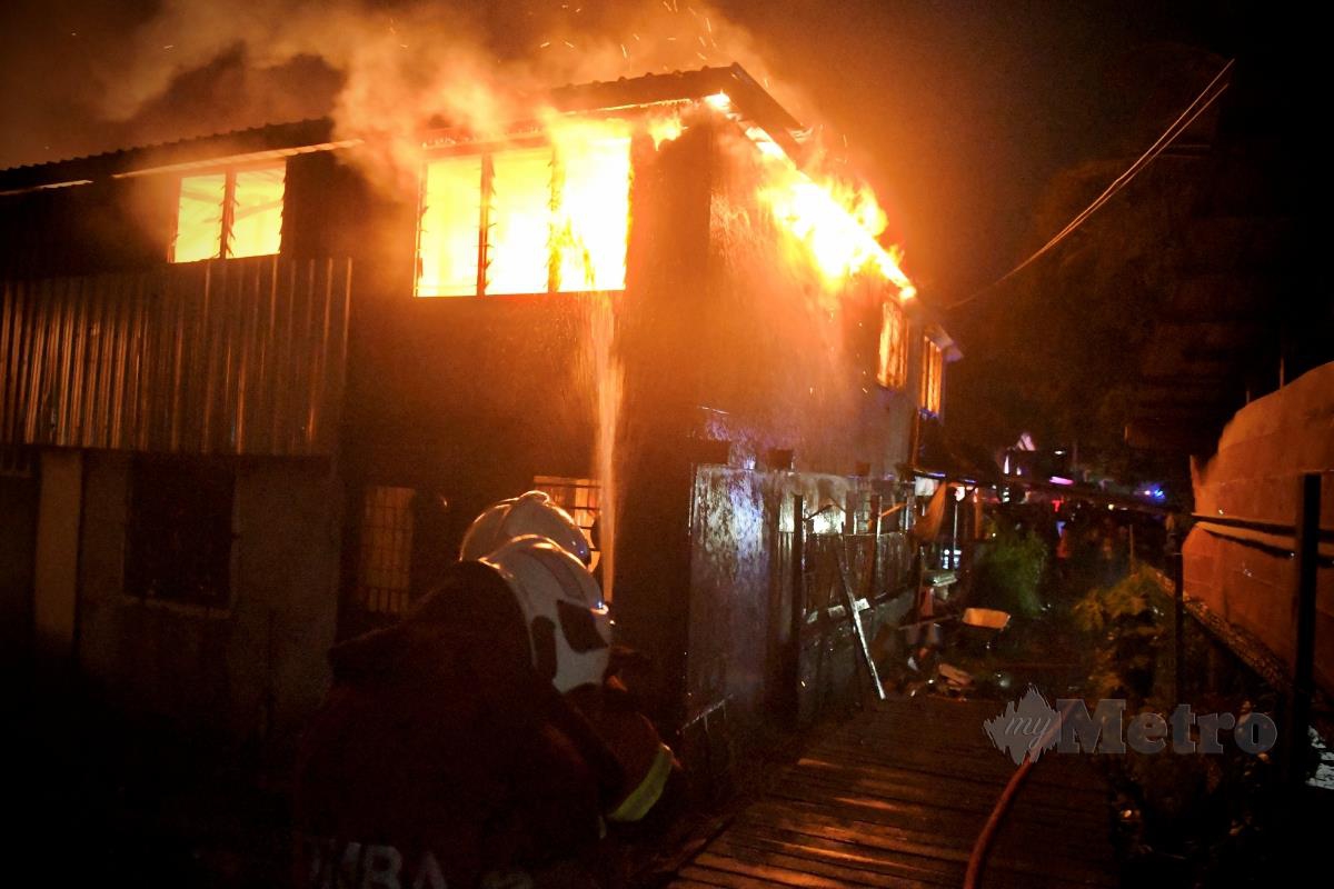 Anggota bomba bertungkus lumus memadamkan api dalam kejadian kebakaran yang memusnahkan beberapa buah rumah di Kampung Kalansanan, dekat Inanam Laut, di sini, malam tadi. Seorang wanita warga emas yang lumpuh ditemui rentung dalam kejadian ini. FOTO MOHD ADAM ARININ