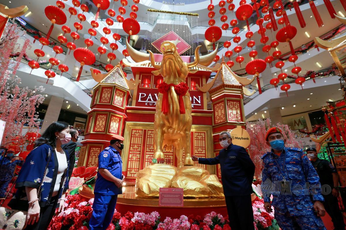 MOHD Redzuan sempat (dua kanan) sempat bergambar dengan replika Lembu emas di Pavilion ketika meninjau masyarakat cina membuat persiapan menyambut Tahun baru Cina pada Perintah Kawalan Pergerakan (PKP) 2.0. FOTO ASWADI ALIAS