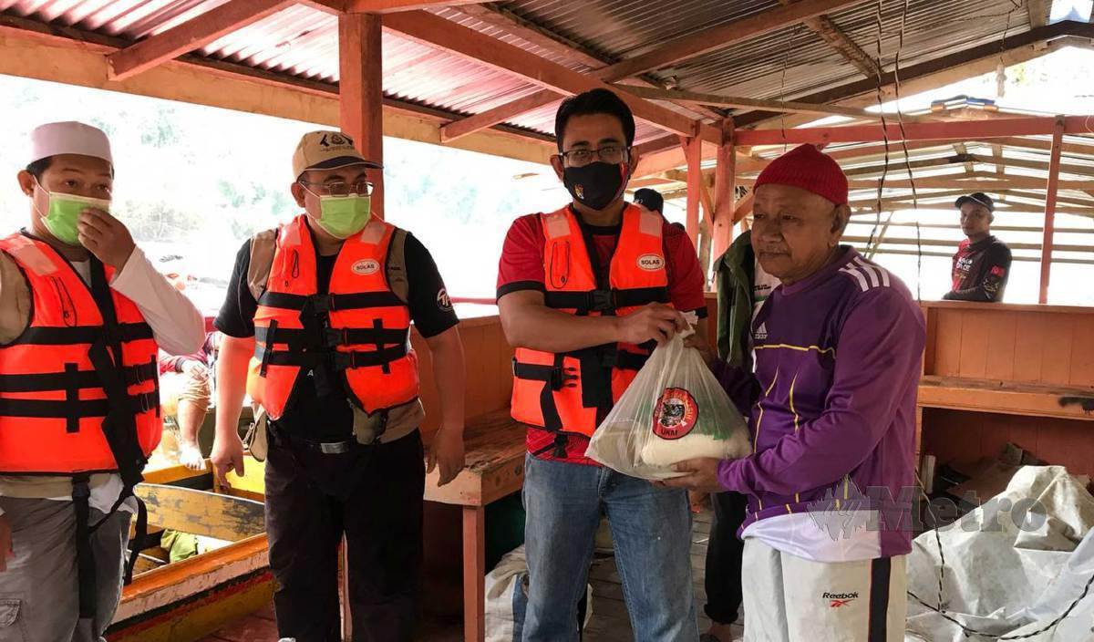 DR Mohd Syuhaimi (dua kanan) menyampaikan sumbangan kepada salah seorang penduduk di Kampung Mambong. FOTO Hazira Ahmad Zaidi