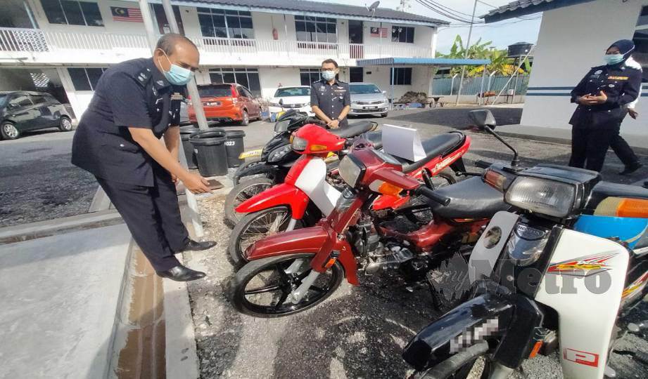 NANDA (kiri) menunjukkan motosikal yang digunakan dalam lumba haram di Lebuhraya Kuala Perlis-Changlun di IPD Arau. FOTO Dziyaul Afnan Abdul Rahman
