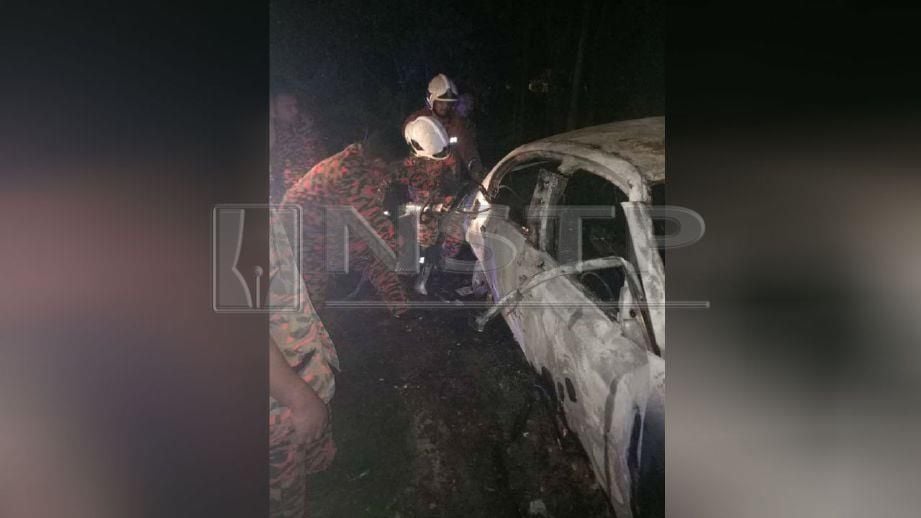  ANGGOTA bomba memeriksa kereta BMW yang terbakar dalam kemalangan. FOTO ihsan polis 