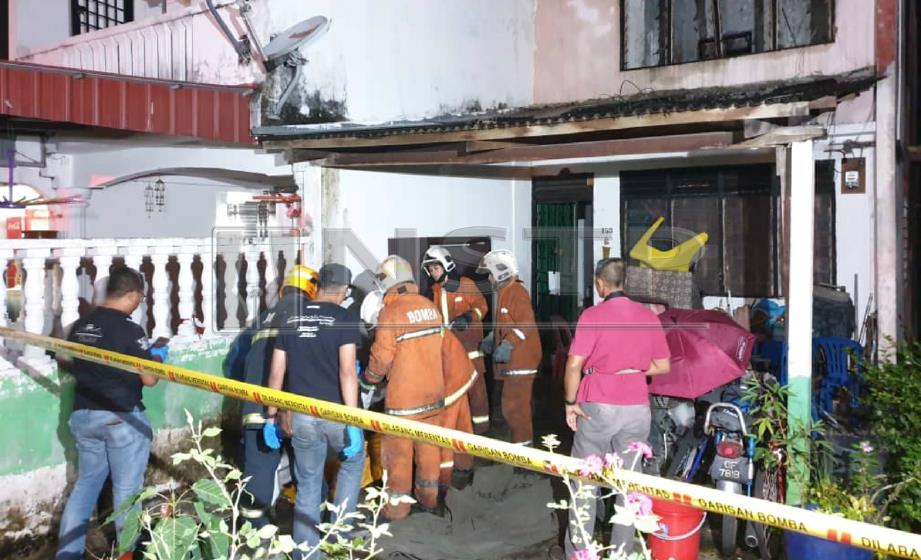 ANGGOTA bomba mengangkat mayat lelaki rentung selepas terperangkap di tingkat atas rumahnya yang terbakar dalam kejadian di Jalan Keembong 18, Taman Johor Jaya, Johor Bahru, hari ini. FOTO Fahmi Yusof. 