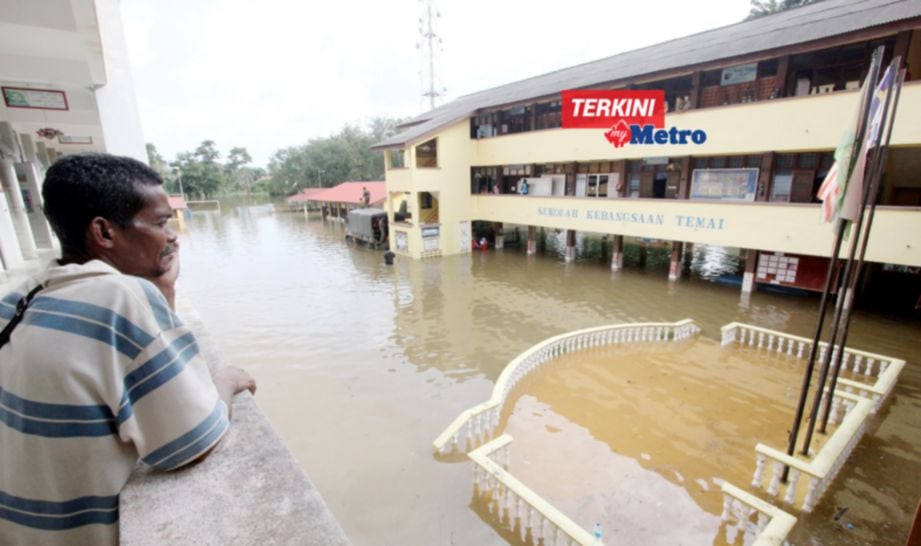 ZAKARIA Awang Ibrahim, 49, merenung keadaan air yang melimpahi kawasan SK Temai, Pekan. Tingkat atas sekolah itu dijadikan PPS. FOTO Bernama 