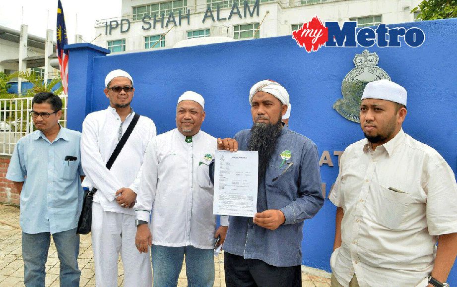 Norazli (dua dari kanan) menunjukkan laporan polis yang dibuat di IPD Shah Alam, hari ini. FOTO Faiz Anuar