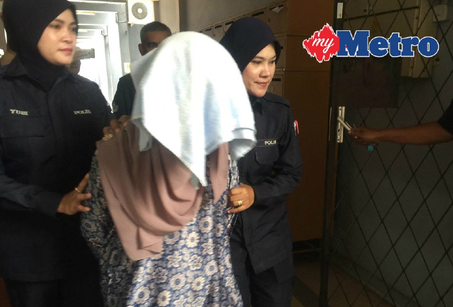 Nor Faezah (tengah) dibawa ke lokap mahkamah sementara menunggu bayaran jaminan selepas didakwa tiga pertuduhan salah guna harta kerajaan, hari ini. FOTO L Manimaran