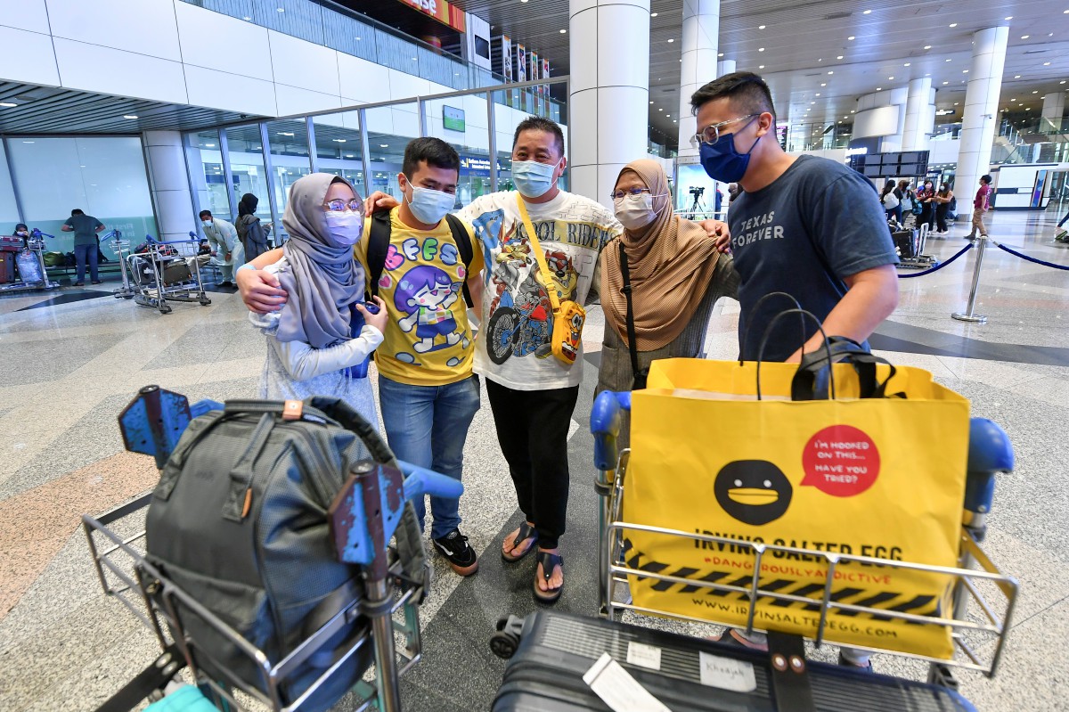 Abdul Jalal (tengah) dan dua anaknya gembira bertemu dengan isterinya, Khadijah (dua dari kanan) dan anak, Mikayl Abdul Jalal, 22 (dua dari kiri) sejurus tiba di KLIA dari Singapura. FOTO BERNAMA