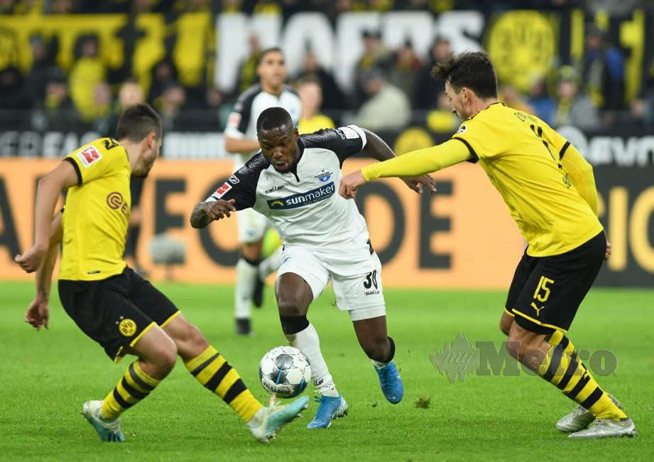 MAMBA (tengah) cuba melepasi kawalan pemain Dortmund, Raphael Guerreiro (kiri) dan Mats Hummels. — FOTO EPA