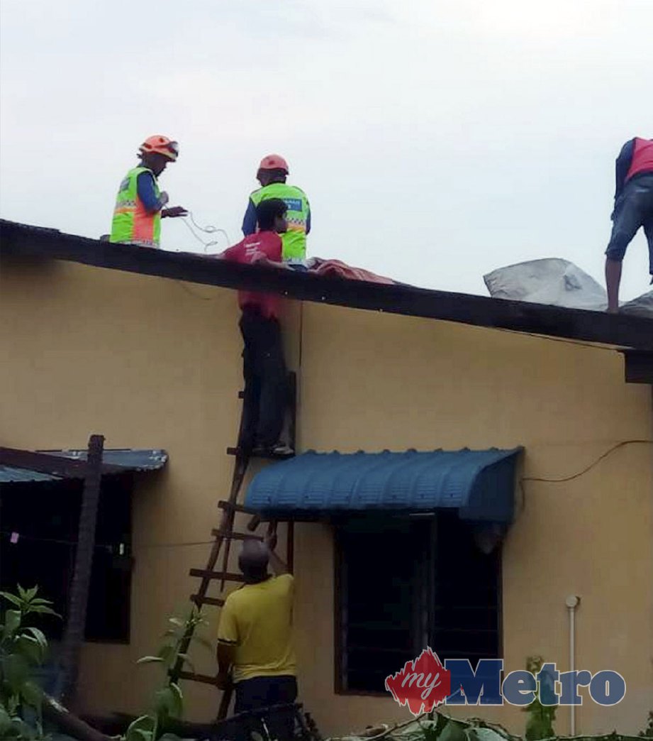 ANGGOTA pasukan keselamatan memeriksa bumbung rumah mangsa yang rosak selepas diterbangkan ribut di Kampung Melayu Batu 10 Skudai. FOTO Ihsan AMP