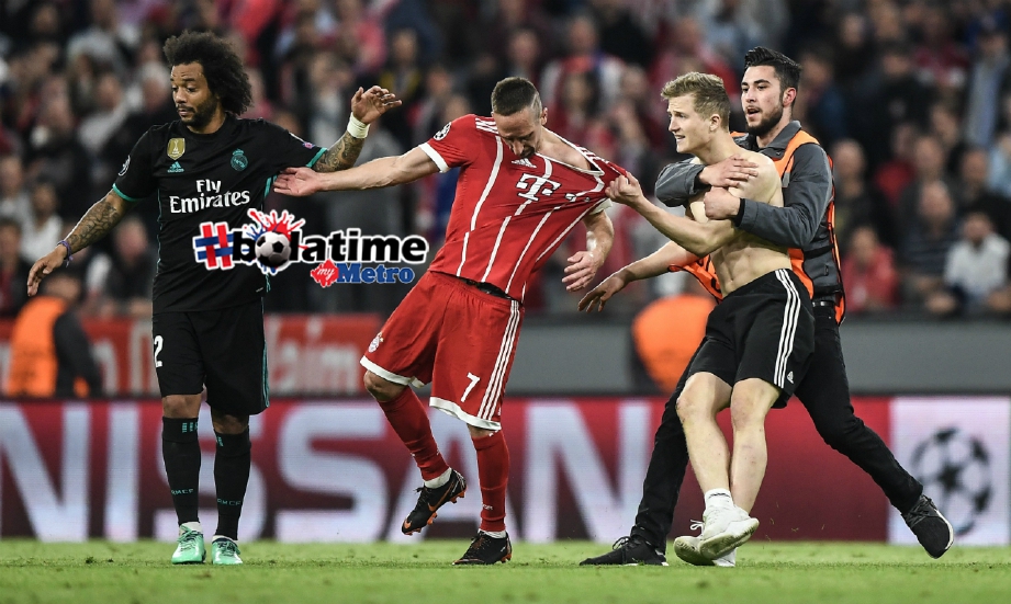 FRANCK Ribery (dua dari kiri) cuba mengelak selepas jersinya ditarik seorang penyokong yang menceroboh padang selepas perlawanan separuh akhir kedua Liga Juara-Juara Eropah di Allianz Arena, Munich, 25 April lalu. FOTO EPA-EFE.