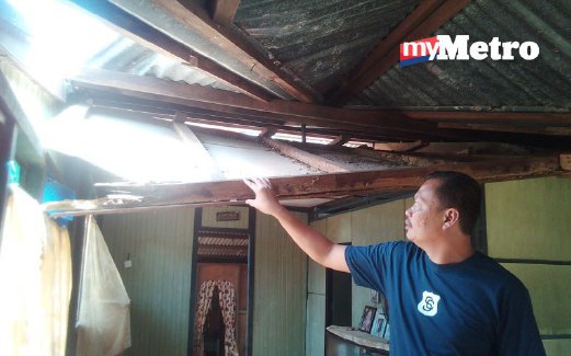 SEORANG mangsa, Affendi Md Resat menunjukkan siling rumahnya yang runtuh  akibat hujan lebat dan angin kencang di FELDA Pasoh 3. 