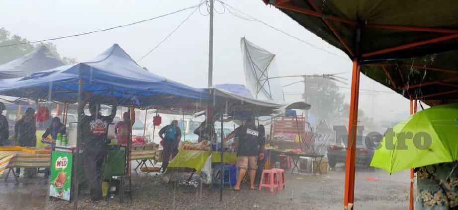 Pengunjung dan peniaga pasar tani Paya Luas berlindung di khemah. FOTO Roselan Ab Malek