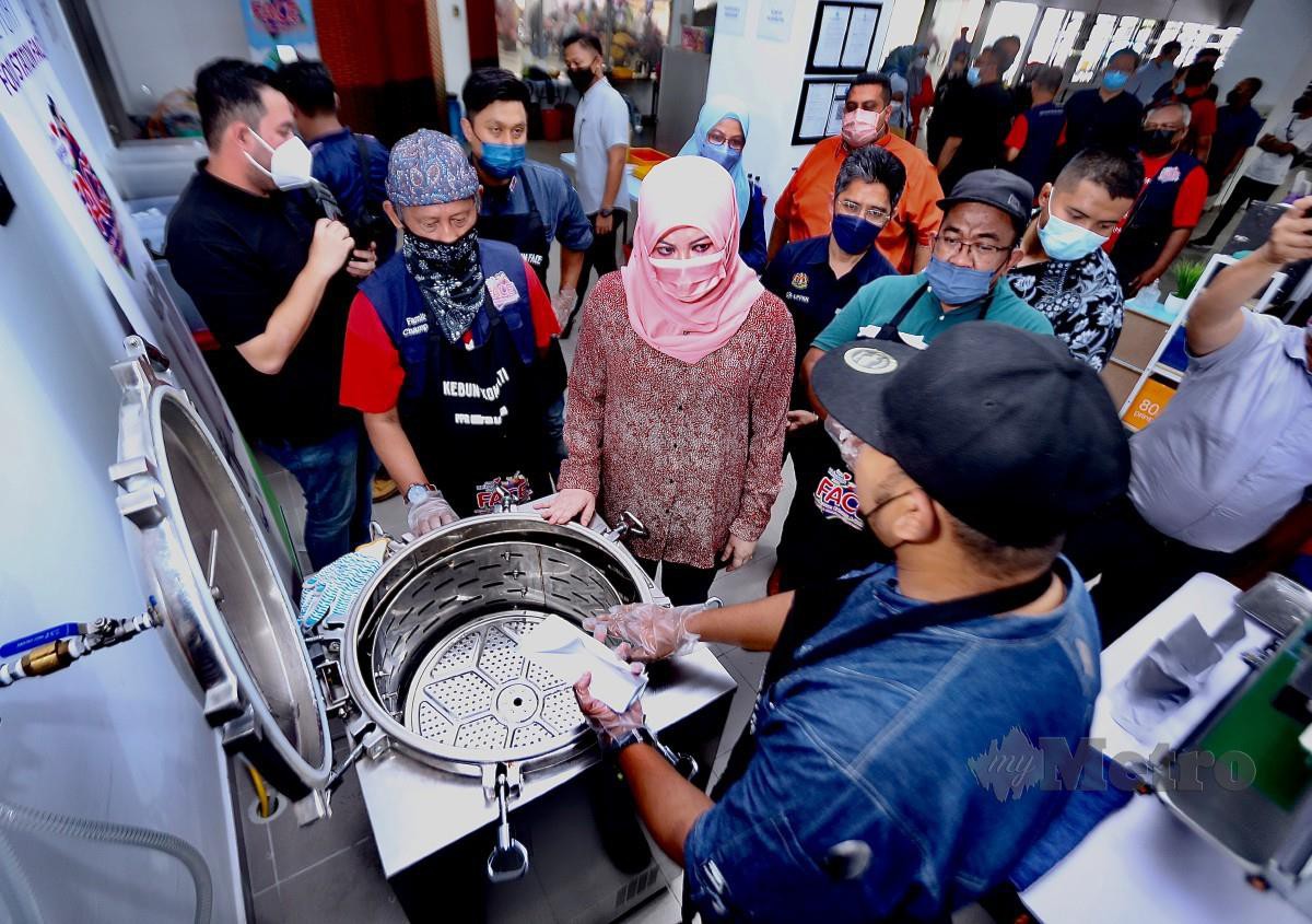 RINA (tengah) mendengar penerangan daripada peserta mengenai proses membuat produk makanan. FOTO Azhar Ramli