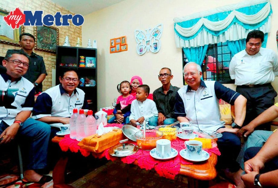 Najib bersama  keluarga Shahril Mohd Sharif, 34, dan isteri Juliana Janggi, 33, serta dua anak mereka, Muhammad Shahmi, 7, dan Safiah Amani, 3, di Majlis Pelancaran RMR1M 10,000 Hasrat Satu Impian di RTB Kampung Bukit Changgang, Kuala Langat, Selangor. FOTO Fariz Iswadi Ismail