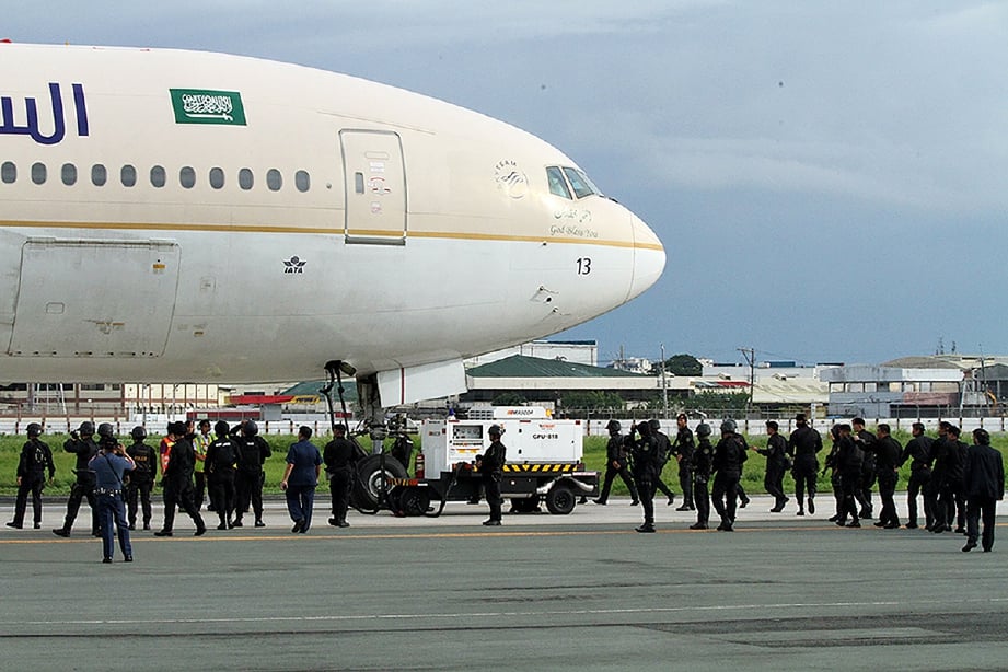 Gambar oleh Pihak Berkuasa Lapangan Terbang Antarabangsa Manila (MIAA) menunjukkan anggota komandi dan SWAT mengepung pesawat. - Foto MIAA/AP
