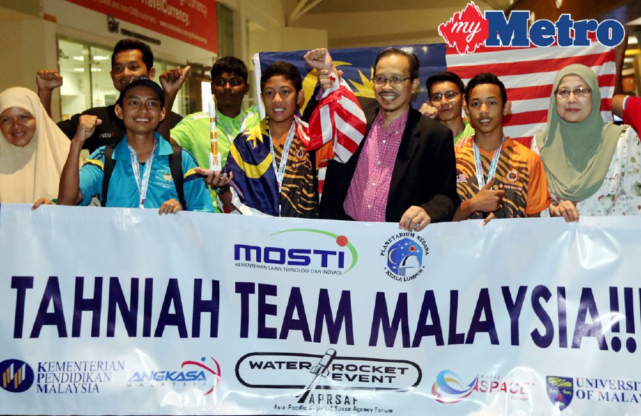 Mohd Azhar Yahaya mengangkat tangan Khairul Ikmal Hakim yang menjuarai kejohanan roket air peringkat Asia Pasifik ketika sambutan kepulangan kontinjen Malaysia di klia2. FOTO MOHD FADLI HAMZAH