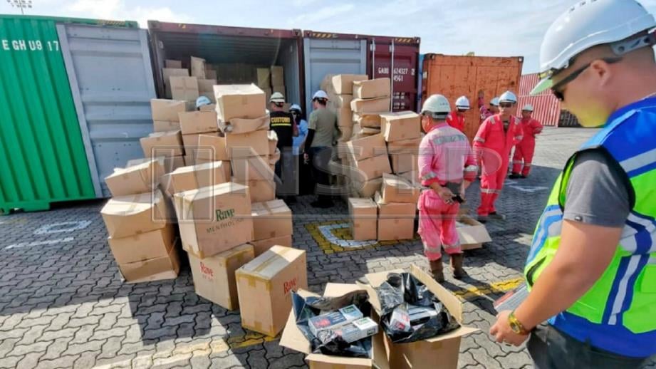 Pegawai kastam memeriksa kontena yang mengandungi rokok putih. FOTO Ihsan Jabatan Kastam Diraja Malaysia