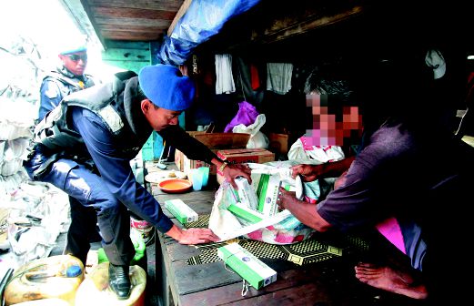 PEGAWAI Operasi dan Risikan PPM, Mohd Rudzuan Ahmad memeriksa bungkusan mengandungi rokok seludup.