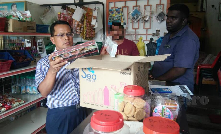 MOHD Sukri (kiri) memeriksa rokok belum lulus kastam yang didapati dijual di kedai runcit di Taman Bandar Baru, Sungai Lalang, Sungai Petani, hari ini. FOTO Nor Farhani Che Ad.
