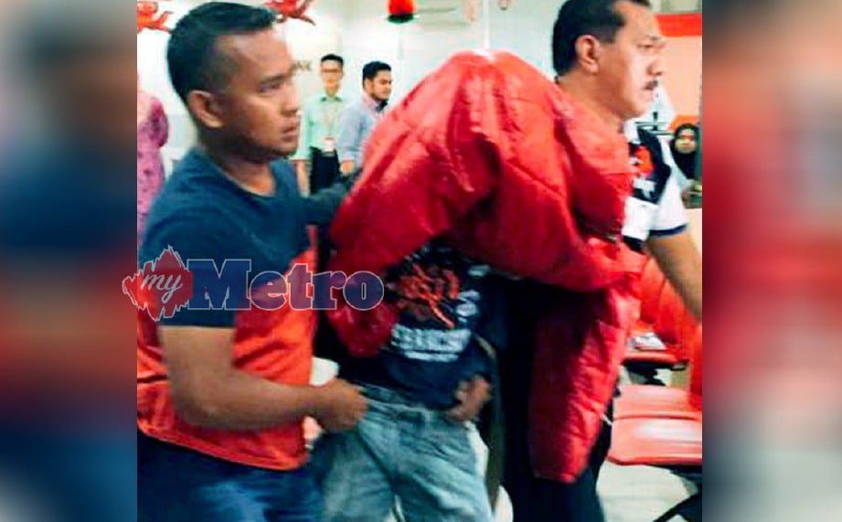 ANGGOTA polis menahan lelaki yang cuba merompak sebuah bank bersenjatakan parang panjang di Tanah Merah, hari ini. FOTO Ihsan Pembaca