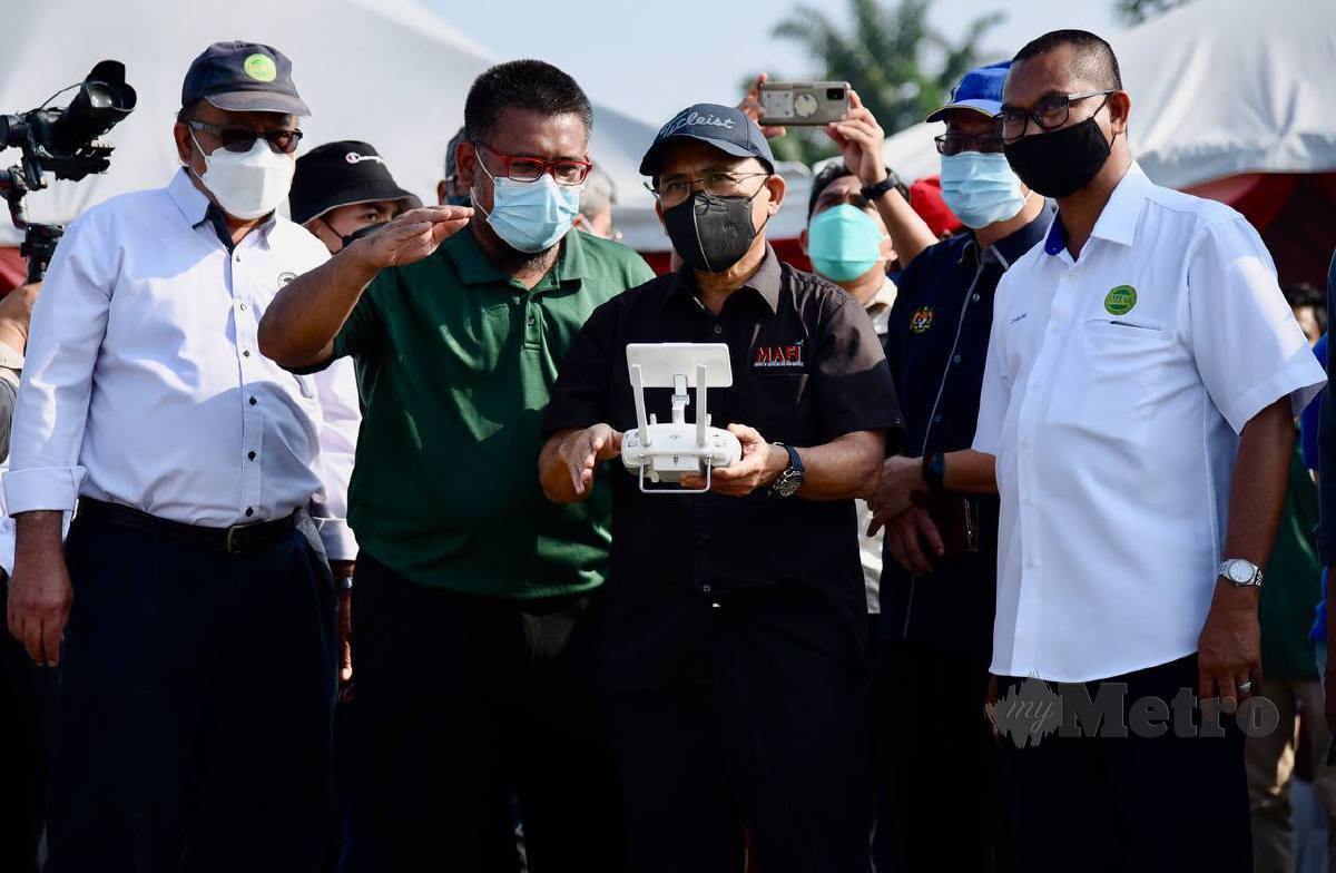 Dr Ronald (tiga dari kiri) mencuba drone untuk menyembur racun selepas merasmikan Pakej Mekanisasi Tanaman Kubis di Tanah Rendah di Mardi Kundang. FOTO FATHIL ASRI