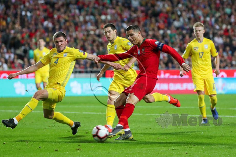 RONALDO diasak dua pemain Ukraine di Lisbon. - FOTO Agensi 