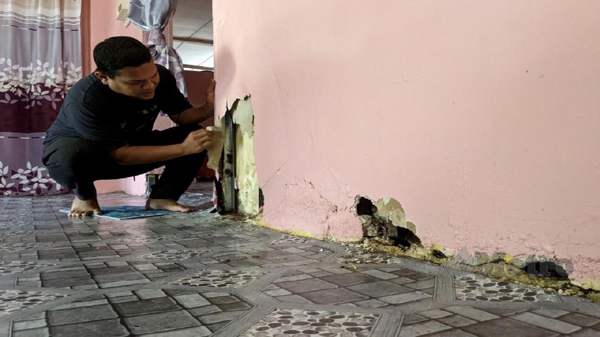 AMRI menunjukkan dinding rumahnya di Kampung Permatang Tepi Bendang, di sini, yang rosak akibat sering ditenggelami banjir. FOTO ZUHAINY ZULKIFFLI