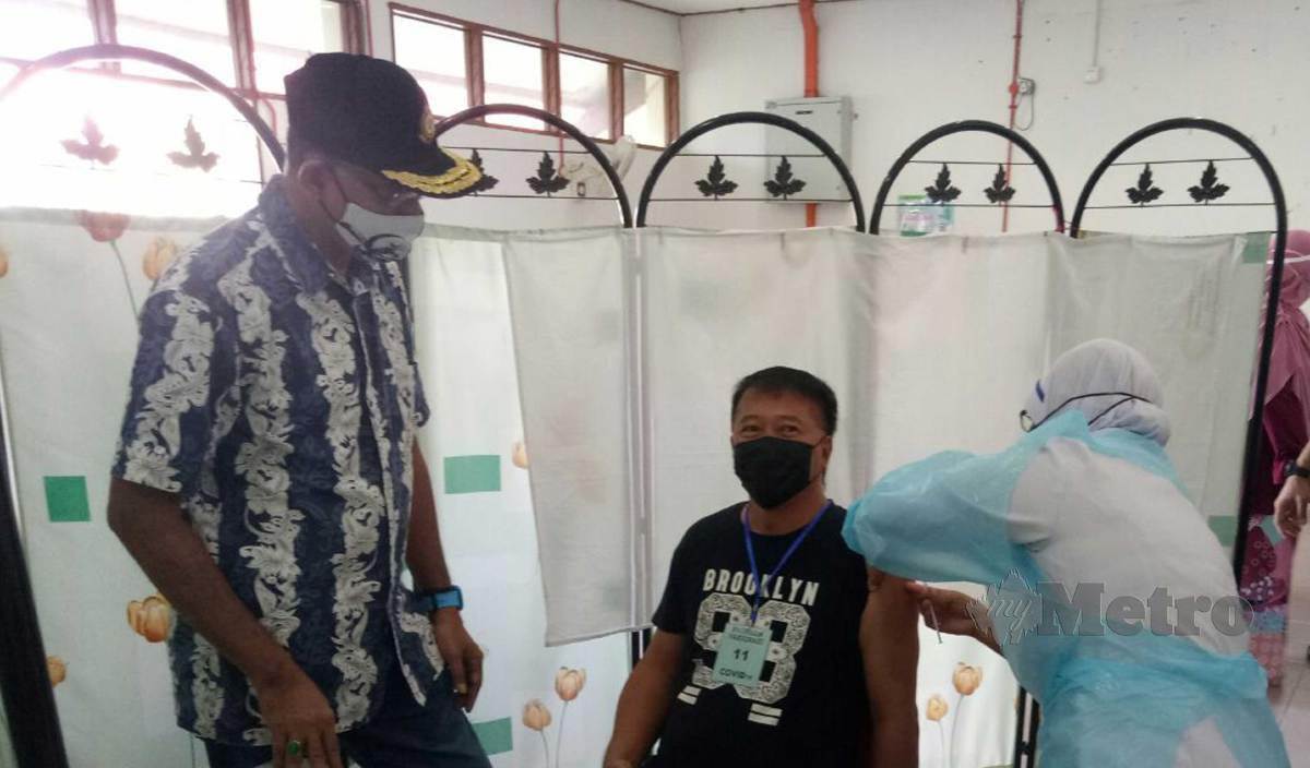 ROSOL (kiri) melihat proses suntikan vaksin dos kedua ketika melawat Klinik Kesihatan Kampung Tengkawang, Kuala Berang.FOTO Baharom Bakar