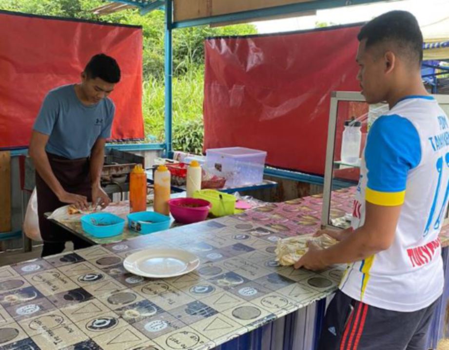 MUHAMMAD Nur Aiman melayan pelanggan di Kampung Bukit Putera Chalok, Setiu.