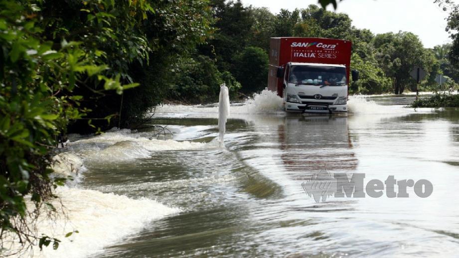 LORI meredah banjir di Jalan Rantau Panjang Lama di Jeram Perdah, Rantau Panjang, hari ini. FOTO Zaman Huri Isa 