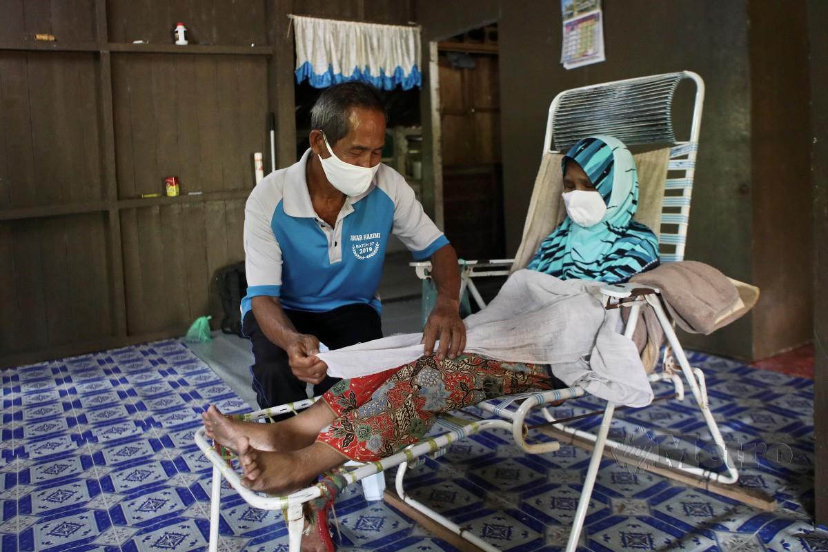 Nordin bersama Kalsom yang terlantar sakit ketika ditemui di kediamannya, Kampung Pasir Raja. FOTO GHAZALI KORI