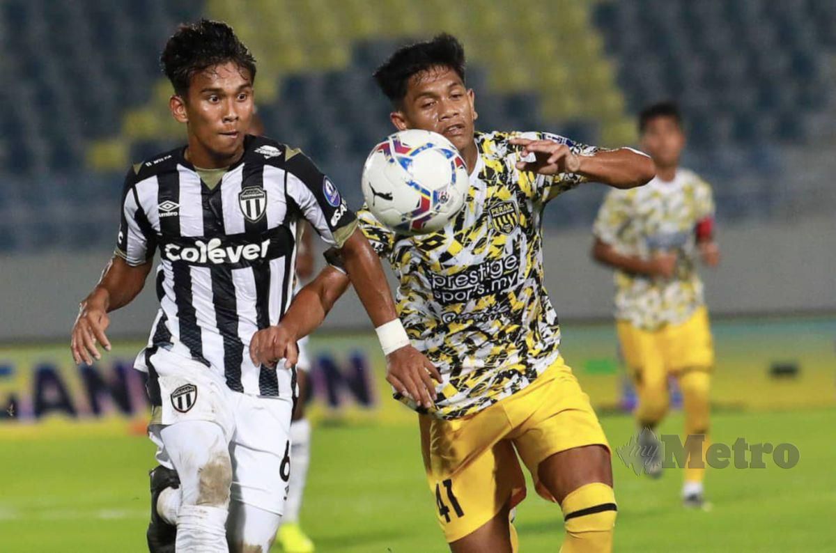 PEMAIN Terengganu FC II, Mohd Syafiq Ismail (kiri) diasak pemain Perak FC, Muhammad Nasrol Amri pada perlawanan Liga Perdana di Stadium Sultan Mizan Zainal Abidin. FOTO Ghazali Kori